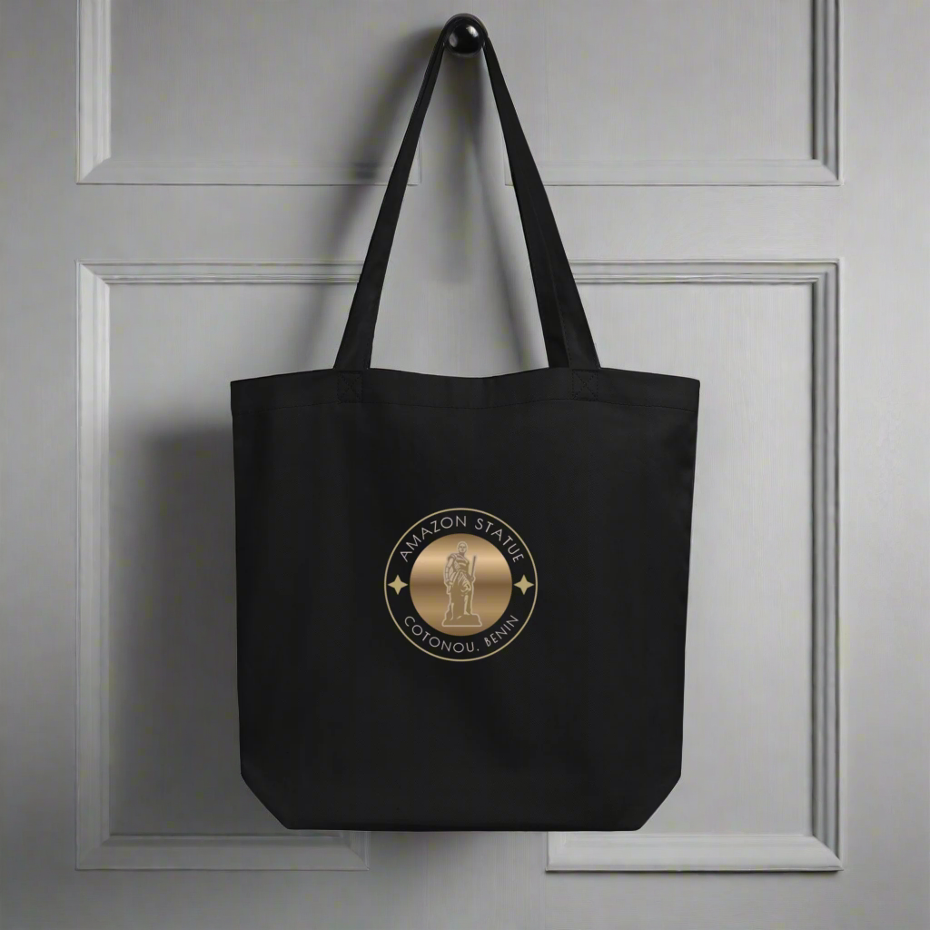 Black tote bag with a gold emblem on a gray background