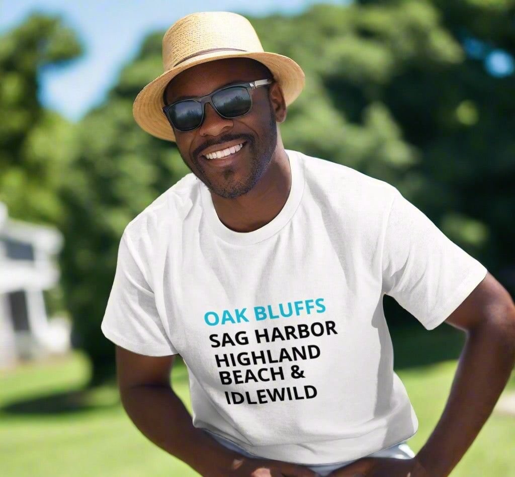 Man wearing a white t-shirt with text, standing outdoors with greenery in the background