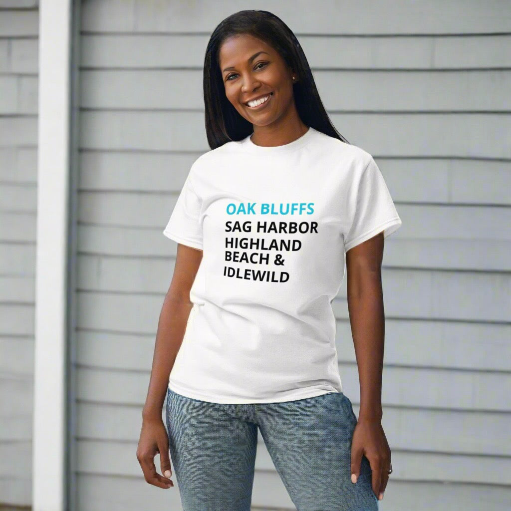 Woman wearing a white t-shirt with text standing against a gray wall.