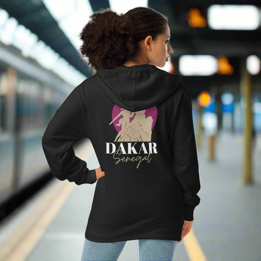 Person wearing a black hoodie with 'DAKAR Senegal' text and graphic, standing on a platform.