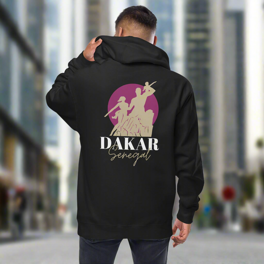 Person wearing a black hoodie with 'Dakar Senegal' design on the back, walking in an urban setting.