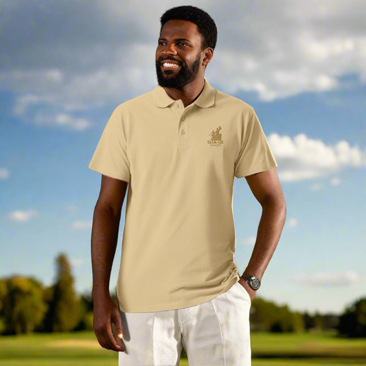 Man wearing a beige polo shirt with a logo on a golf course