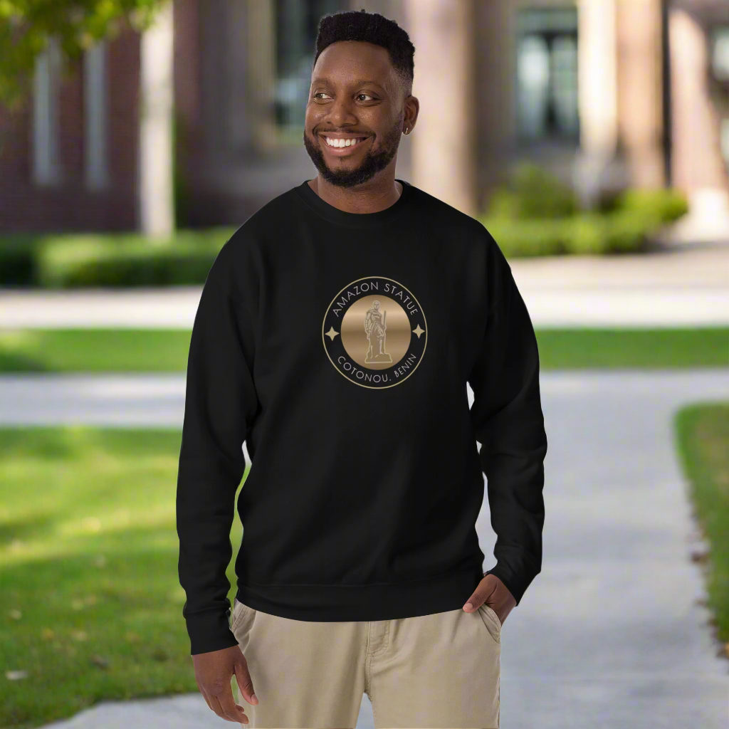 Man wearing a black sweatshirt with a logo, standing outdoors on a path.