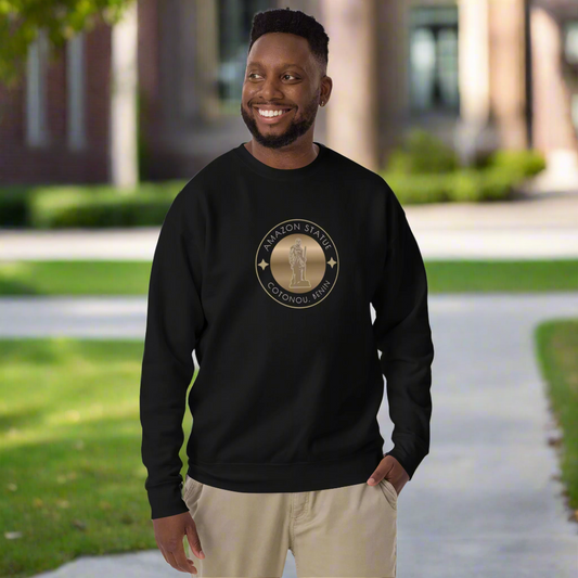 Man wearing a black sweatshirt with a logo, standing outdoors on a path.