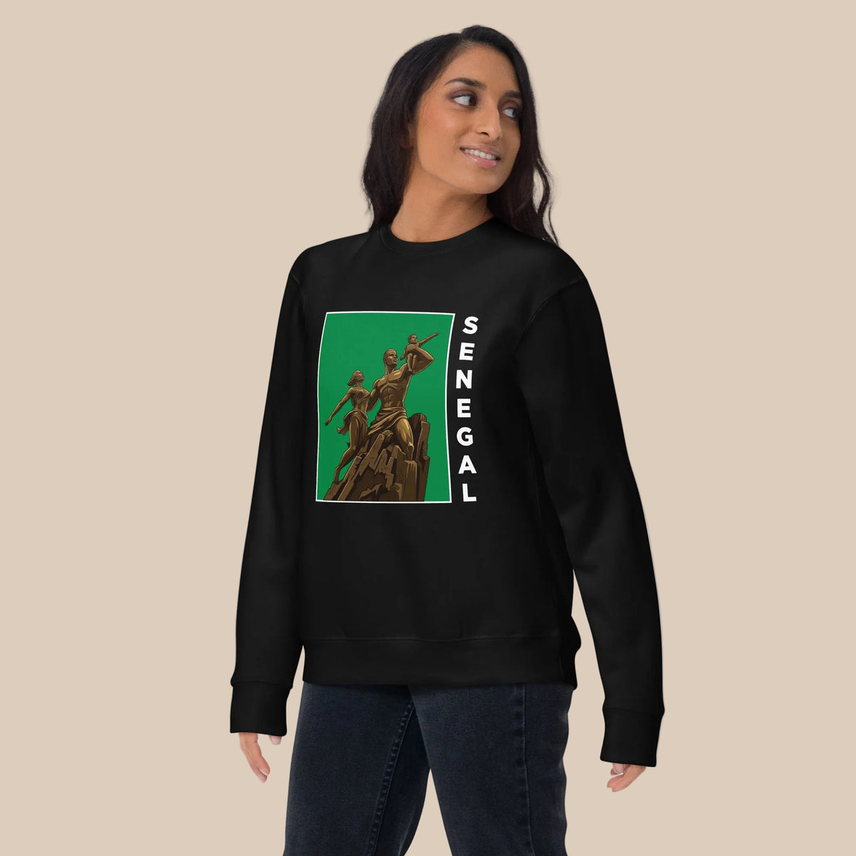 Model wearing a black crewneck sweatshirt with an African Renaissance Monument graphic on green and white vertical Senegal lettering.