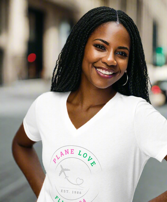 Woman wearing a white t-shirt with a logo and text, standing on a city street.